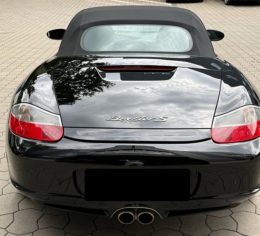 Heck des schwarzen Porsche Boxster S, der Himmel spiegelt sich gleichm&auml;&szlig;ig im Lack