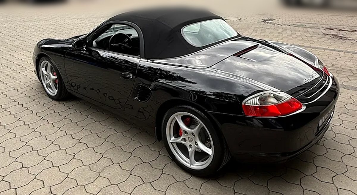 Schwarzer Porsche Boxster S von schr&auml;g hinten, Lack und Felgen spiegeln nach der Aufbereitung